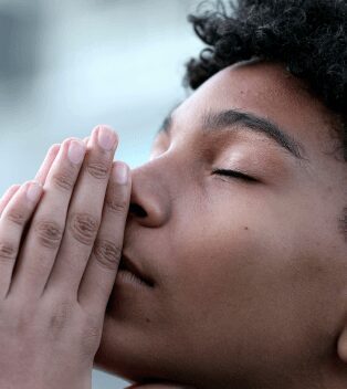 A close up of a person with their hands over his mouth