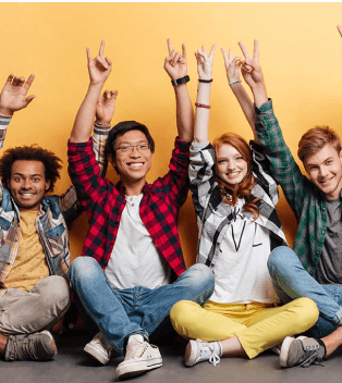 A group of people sitting on the ground with their hands in the air.
