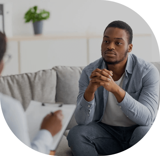 A man sitting on the couch talking to someone