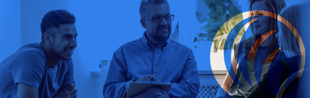 A man with glasses is writing on paper