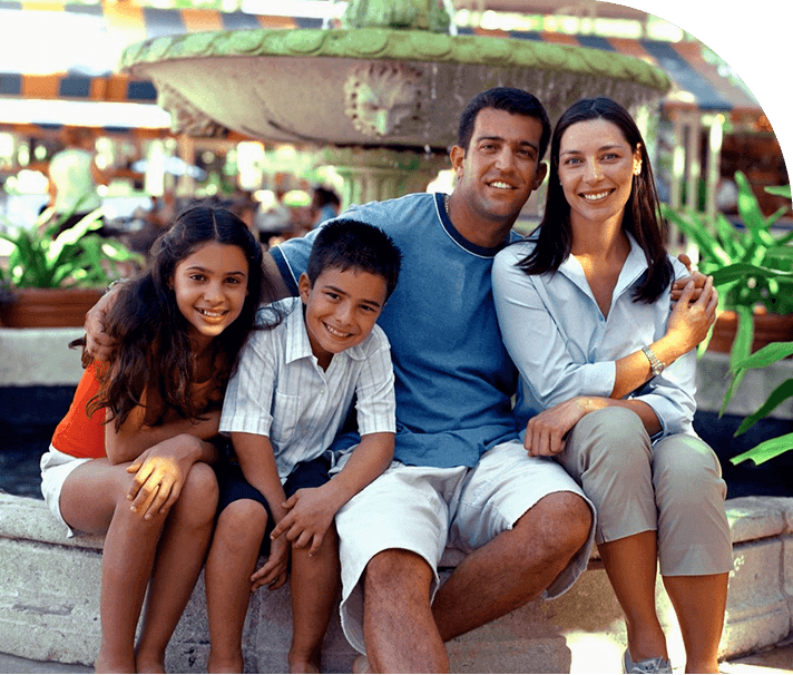 A family posing for the camera in front of a fountain.